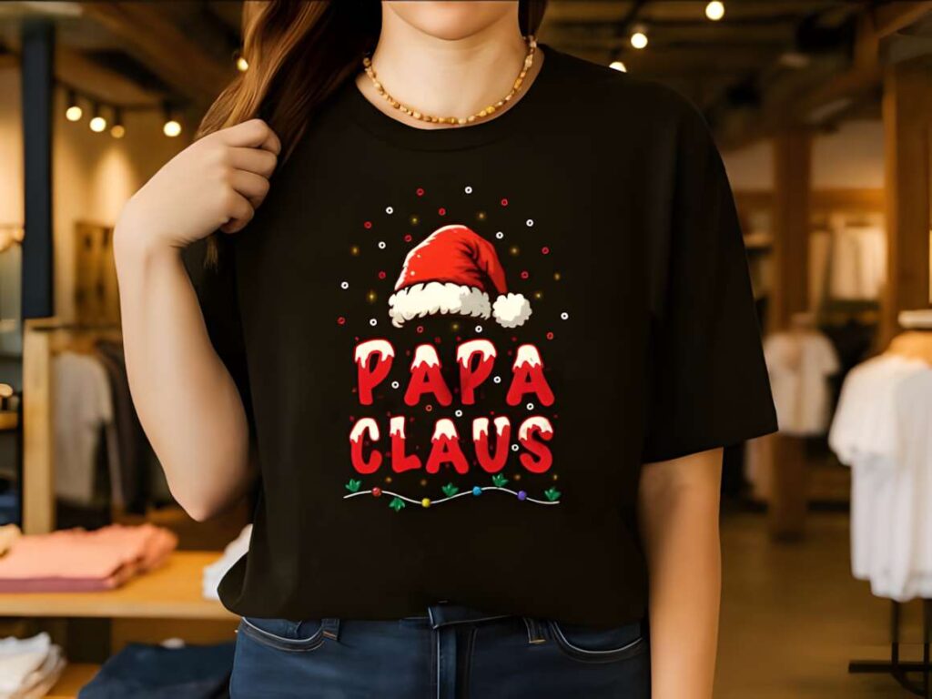 Christmas t-shirt design ideas for POD sellers featuring a black shirt with red text 'Papa Claus' and a Santa hat graphic
